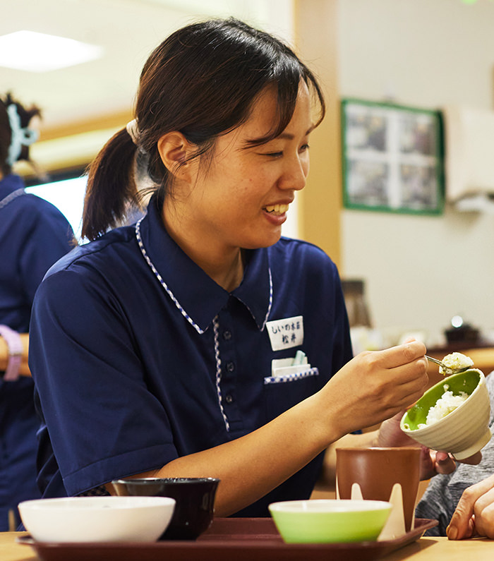 スタッフが車椅子の高齢者を介助している様子